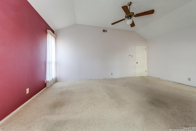 carpeted empty room featuring vaulted ceiling and ceiling fan