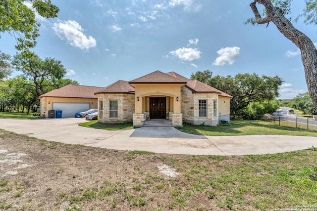 mediterranean / spanish home with a garage and a front lawn