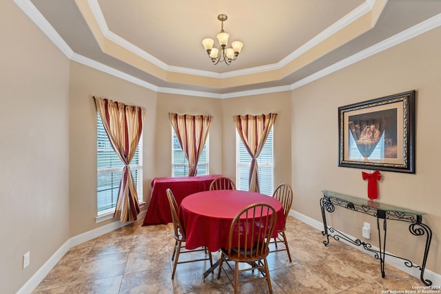 dining area with a chandelier, crown molding, and a raised ceiling