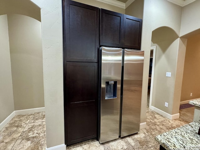 kitchen featuring stainless steel refrigerator with ice dispenser and light stone countertops