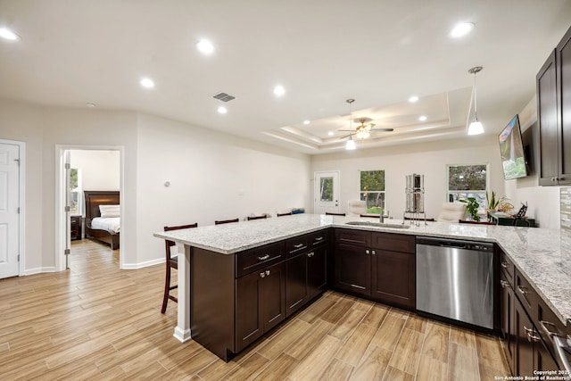 kitchen with pendant lighting, sink, a breakfast bar area, dishwasher, and kitchen peninsula