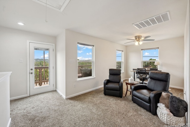 living area featuring carpet and ceiling fan