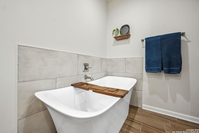 bathroom with a bathtub and tile walls