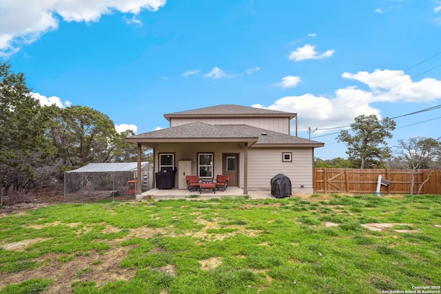 rear view of property with a yard and a patio area