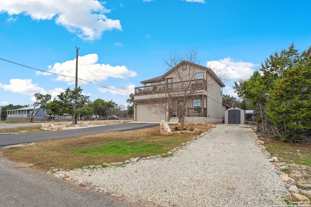 view of front facade with a garage, a balcony, and a storage shed