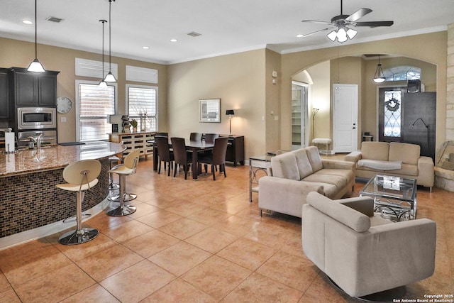 tiled living room featuring ceiling fan, ornamental molding, and sink