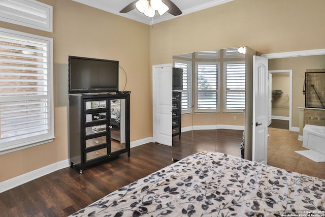 bedroom featuring dark wood-type flooring, ornamental molding, and ceiling fan