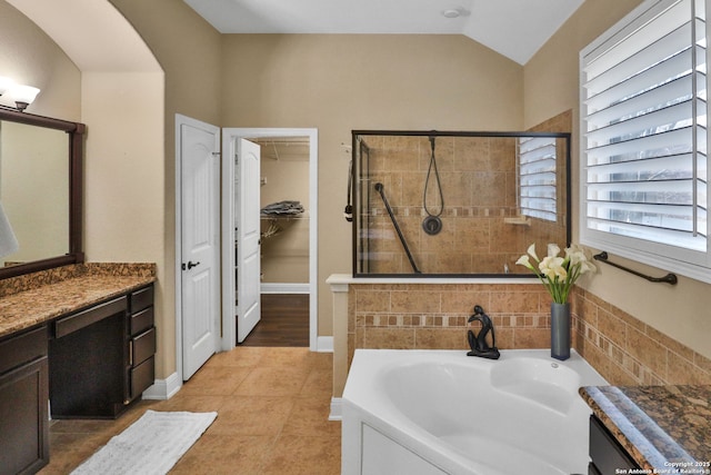 bathroom featuring vanity, tile patterned flooring, lofted ceiling, and separate shower and tub