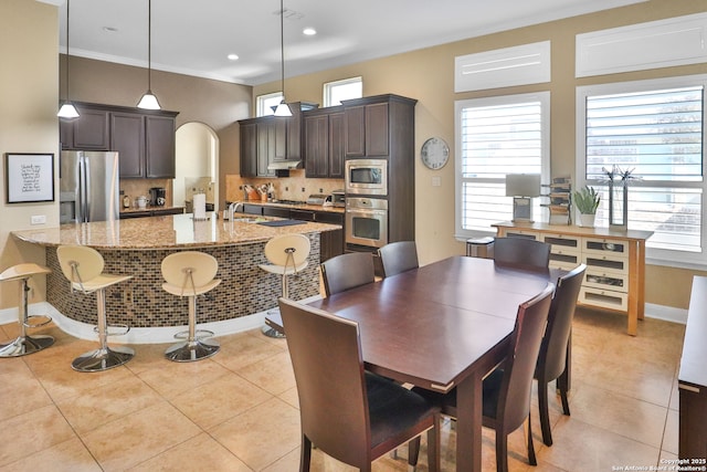 dining area featuring crown molding and light tile patterned floors