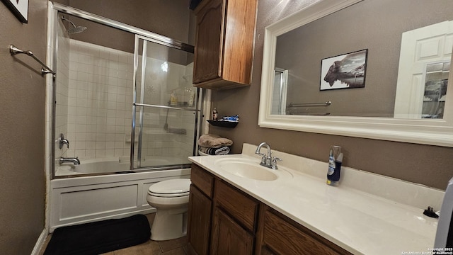 full bathroom with tile patterned floors, toilet, vanity, and enclosed tub / shower combo