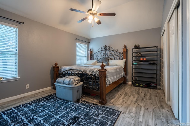 bedroom with hardwood / wood-style flooring, a closet, vaulted ceiling, and ceiling fan