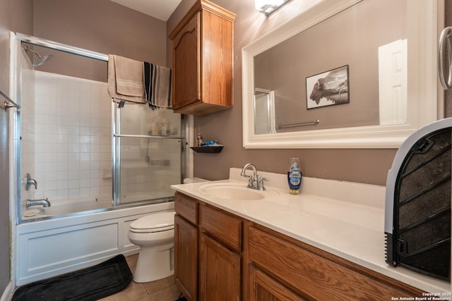 full bathroom with tile patterned floors, toilet, vanity, and shower / bath combination with glass door