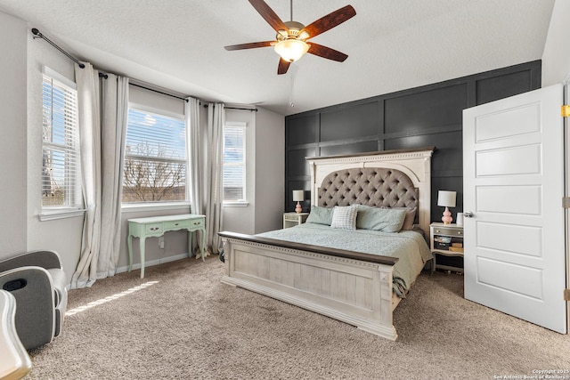 carpeted bedroom featuring ceiling fan, multiple windows, and a textured ceiling