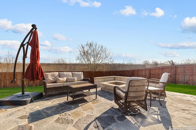 view of patio with an outdoor living space with a fire pit