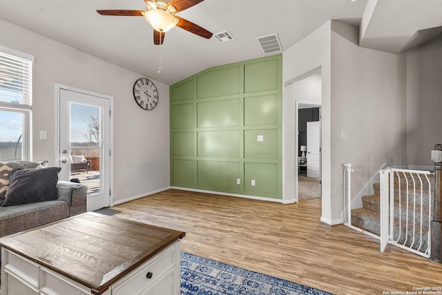 living room featuring lofted ceiling, light hardwood / wood-style flooring, and ceiling fan