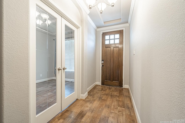 doorway to outside featuring ornamental molding, wood-type flooring, and french doors