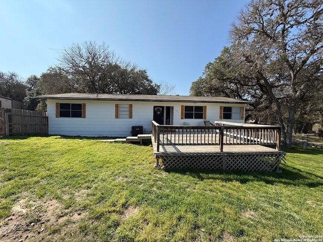 back of house featuring a deck and a lawn