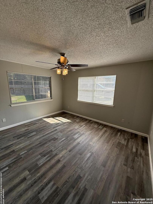 empty room featuring ceiling fan, dark hardwood / wood-style floors, and a textured ceiling