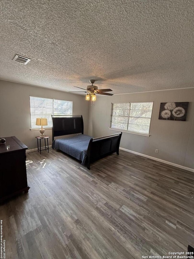 unfurnished bedroom featuring ceiling fan, wood-type flooring, and a textured ceiling