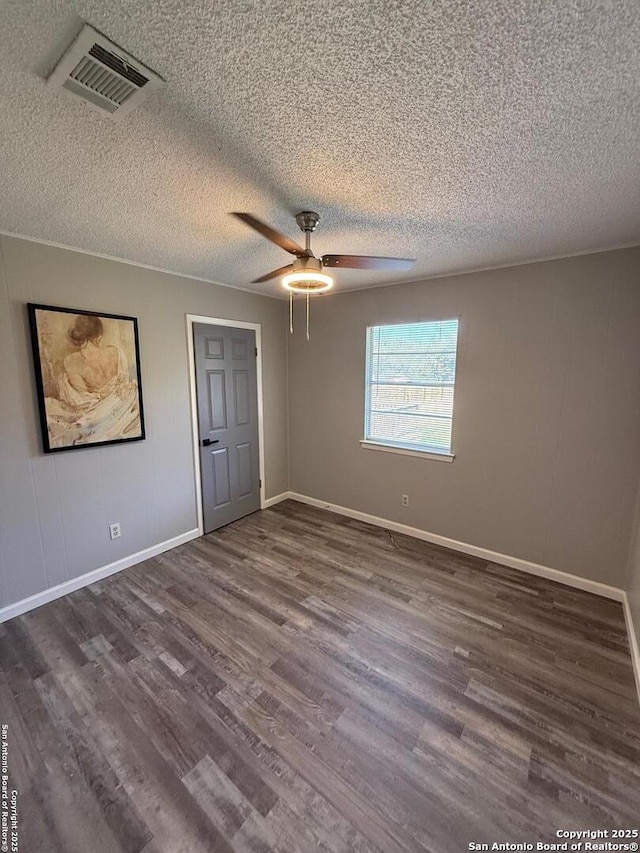 unfurnished bedroom with dark wood-type flooring, a textured ceiling, and ceiling fan