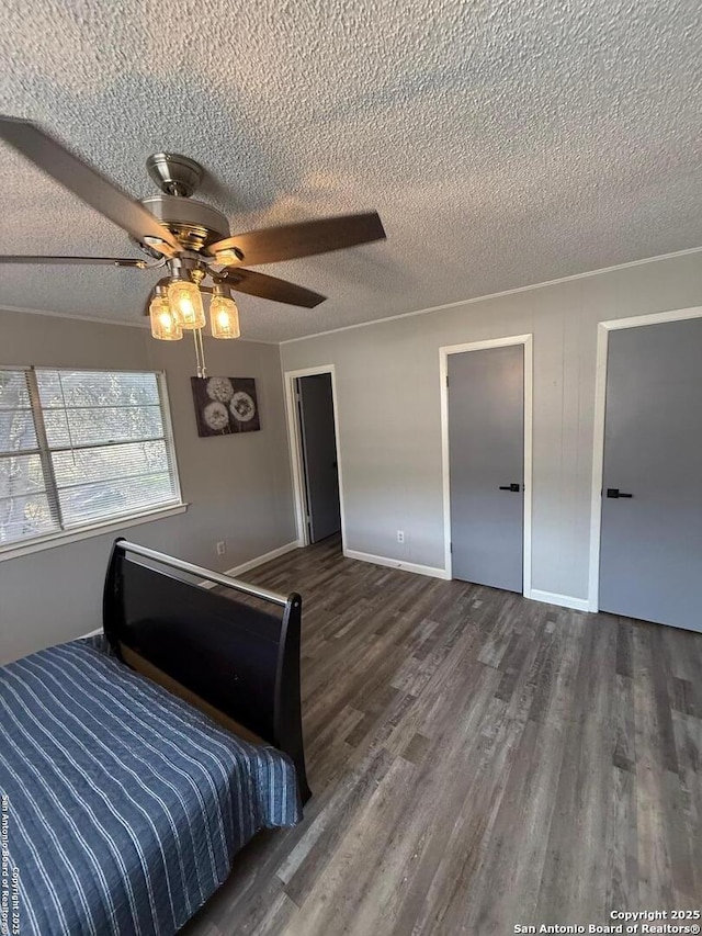 unfurnished bedroom with ceiling fan, dark hardwood / wood-style floors, and a textured ceiling