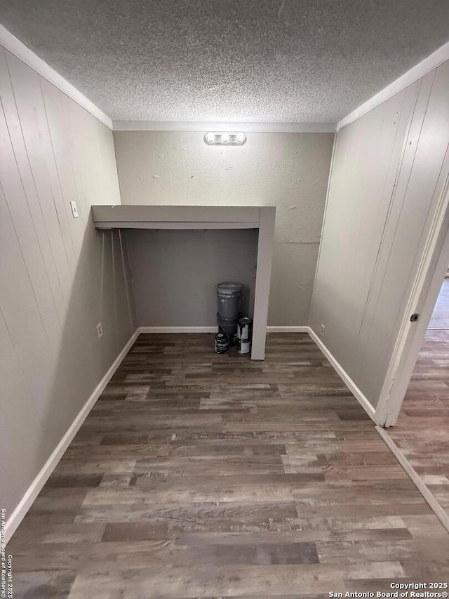 interior space with a textured ceiling and dark hardwood / wood-style flooring