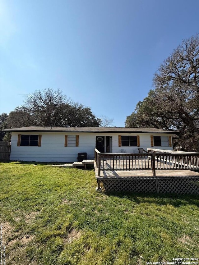 rear view of house featuring a deck and a lawn