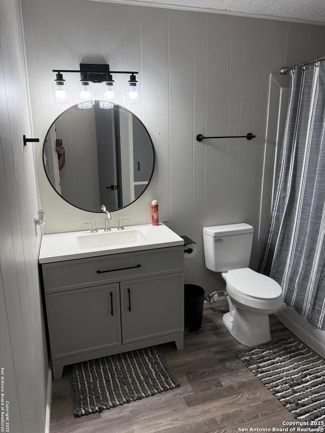 bathroom featuring walk in shower, toilet, a textured ceiling, vanity, and hardwood / wood-style floors