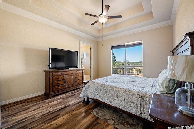 bedroom with ceiling fan, a tray ceiling, dark hardwood / wood-style flooring, and ornamental molding