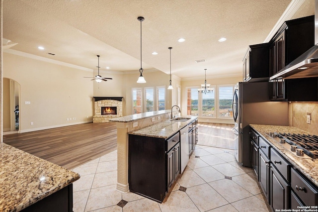 kitchen featuring sink, pendant lighting, wall chimney exhaust hood, and a large island