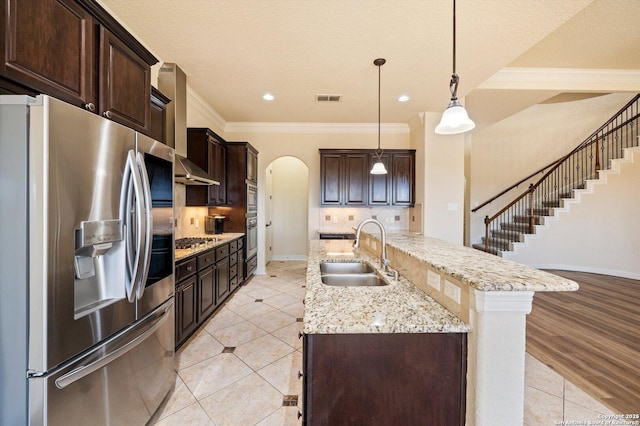 kitchen with sink, light tile patterned flooring, pendant lighting, stainless steel appliances, and decorative backsplash