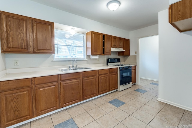 kitchen with white range with gas cooktop, sink, and light tile patterned floors