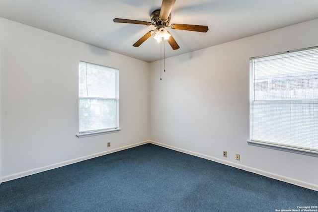 carpeted spare room featuring ceiling fan and a wealth of natural light