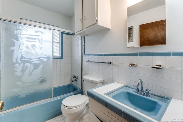 full bathroom with enclosed tub / shower combo, tile walls, tile patterned flooring, vanity, and toilet