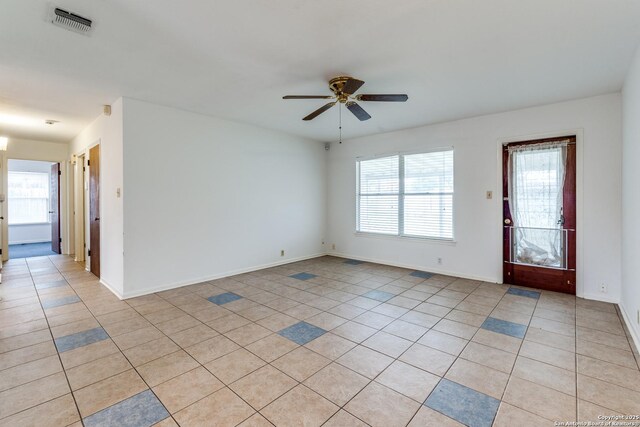 empty room featuring light tile patterned floors and ceiling fan