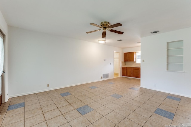 tiled empty room with built in features and ceiling fan