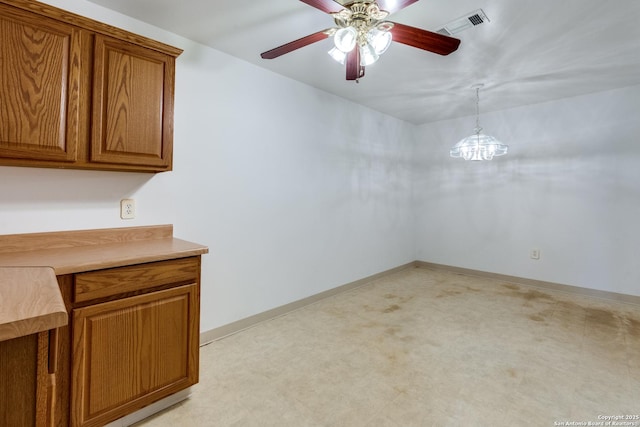 unfurnished dining area featuring ceiling fan with notable chandelier