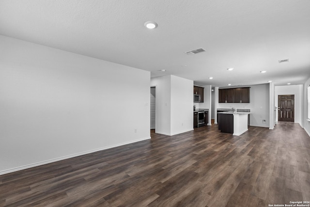 unfurnished living room with dark hardwood / wood-style floors, sink, and a textured ceiling