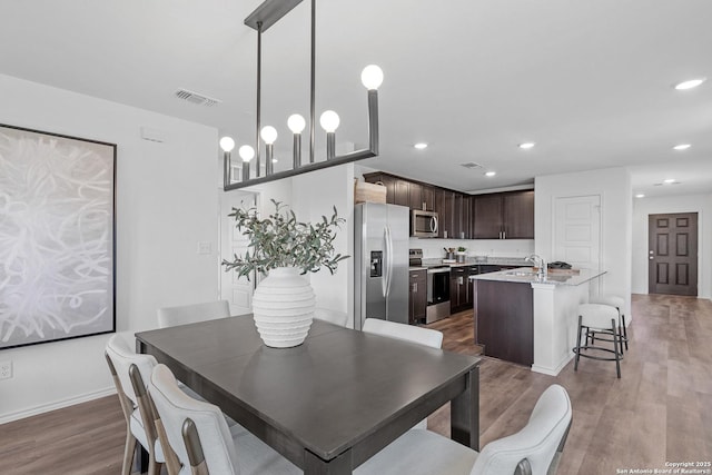 dining area featuring hardwood / wood-style flooring and sink