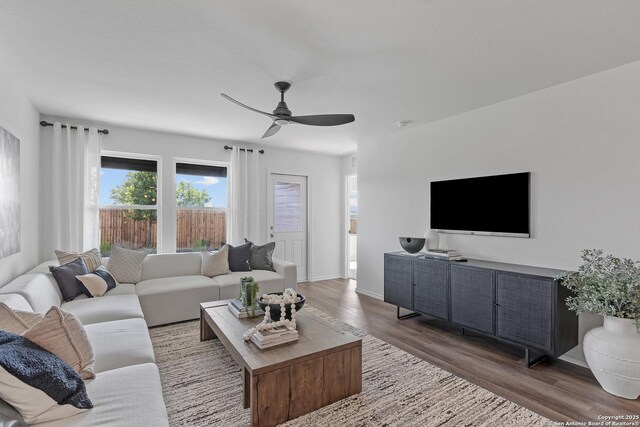 living room featuring dark hardwood / wood-style flooring and ceiling fan