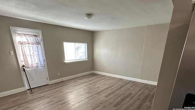 foyer featuring wood finished floors and baseboards