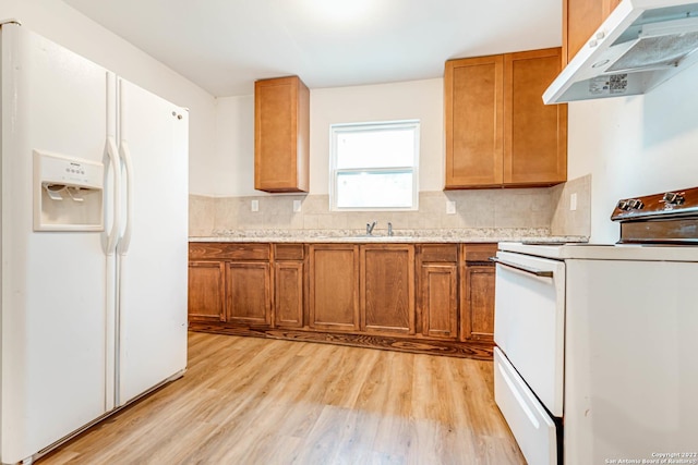 kitchen with white appliances, sink, light hardwood / wood-style flooring, and backsplash