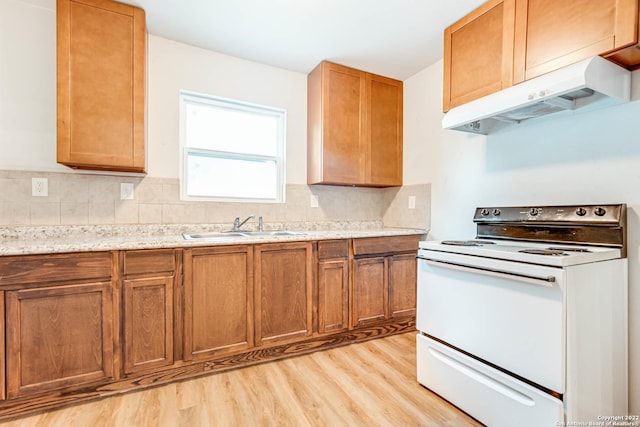 kitchen featuring electric stove, sink, light stone counters, light hardwood / wood-style floors, and decorative backsplash