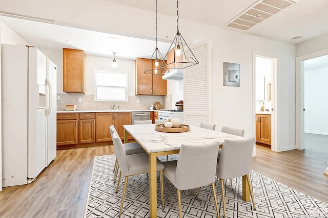 dining space with sink and light hardwood / wood-style floors