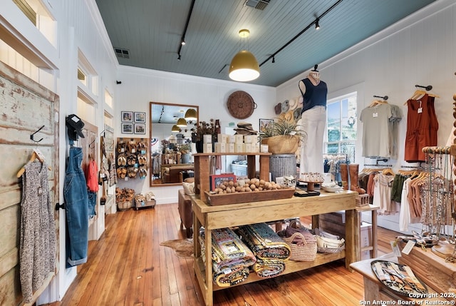 interior space featuring track lighting, ornamental molding, and light wood-type flooring