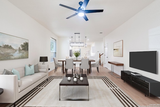 living room with ceiling fan and light hardwood / wood-style flooring