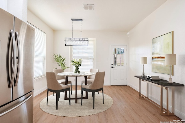 dining room with plenty of natural light and light hardwood / wood-style flooring