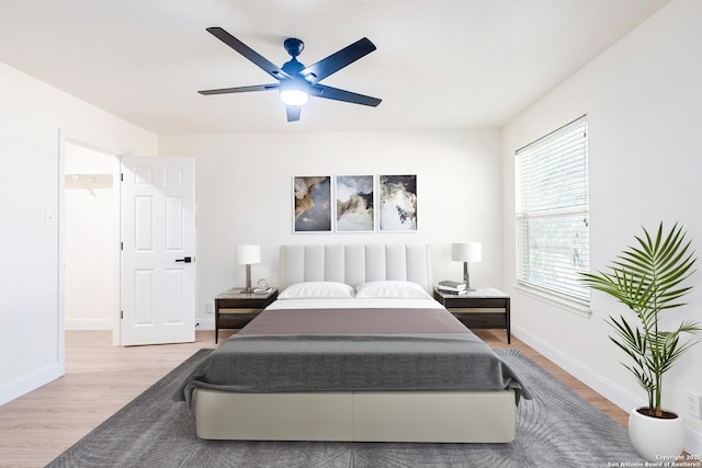 bedroom featuring hardwood / wood-style flooring, a spacious closet, and ceiling fan