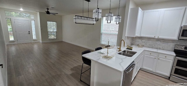 kitchen featuring white cabinetry, appliances with stainless steel finishes, and kitchen peninsula