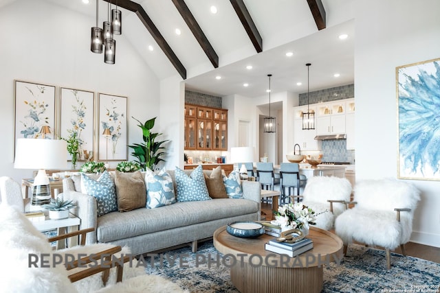 living room with beam ceiling and high vaulted ceiling